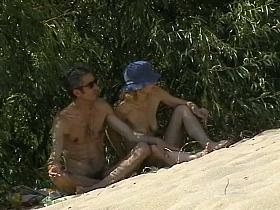 Couple taking sunbaths and walking nakes on the beach