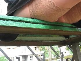 Girl in stockings sitting on a bench