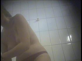 A girl is undressing in the swimming pool changing room