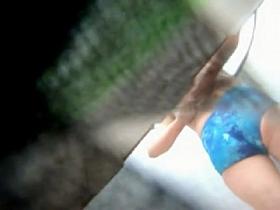 Man behind the beach changing cabin spies female