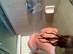 Busty babe gets caught on tape washing her voluptuous tanned body