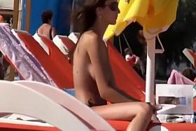 Topless girl reading and sunbathing